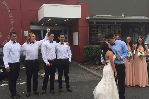 عروسان يحتفلان بزواجهما خارج مطعم كنتاكي للوجبات السريعة